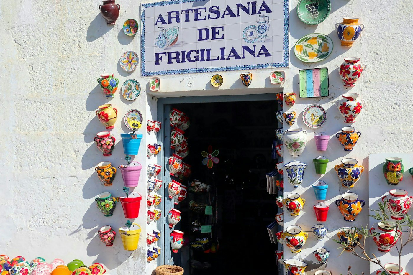 Poteries colorées devant l'entrée d'une boutique