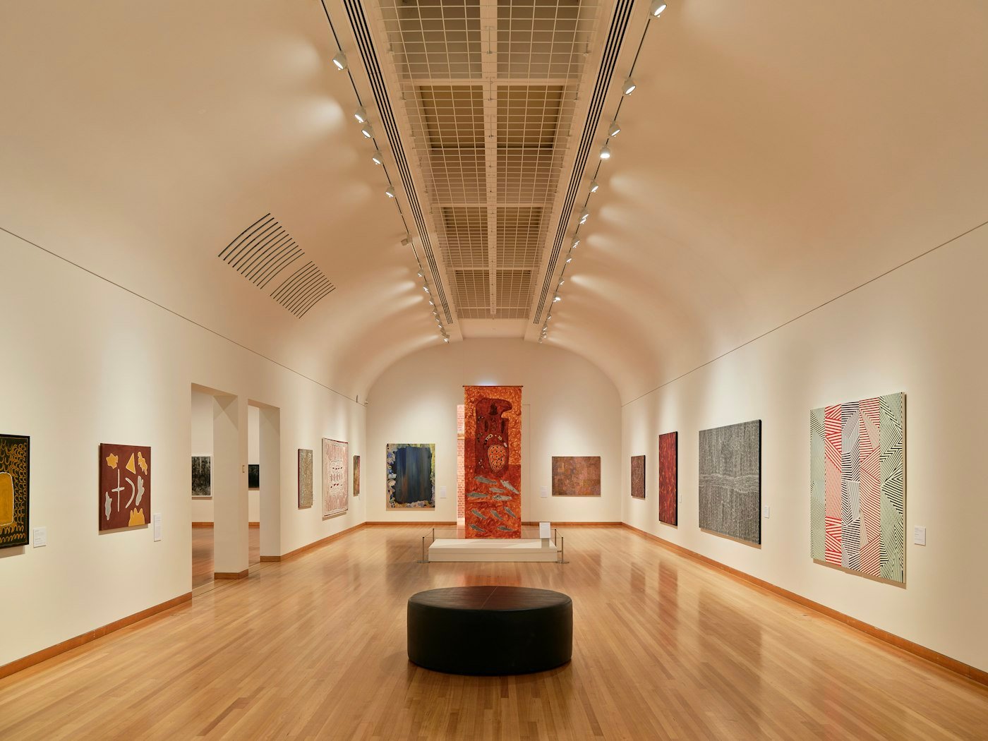 Salle d'exposition aux murs couverts de tableaux