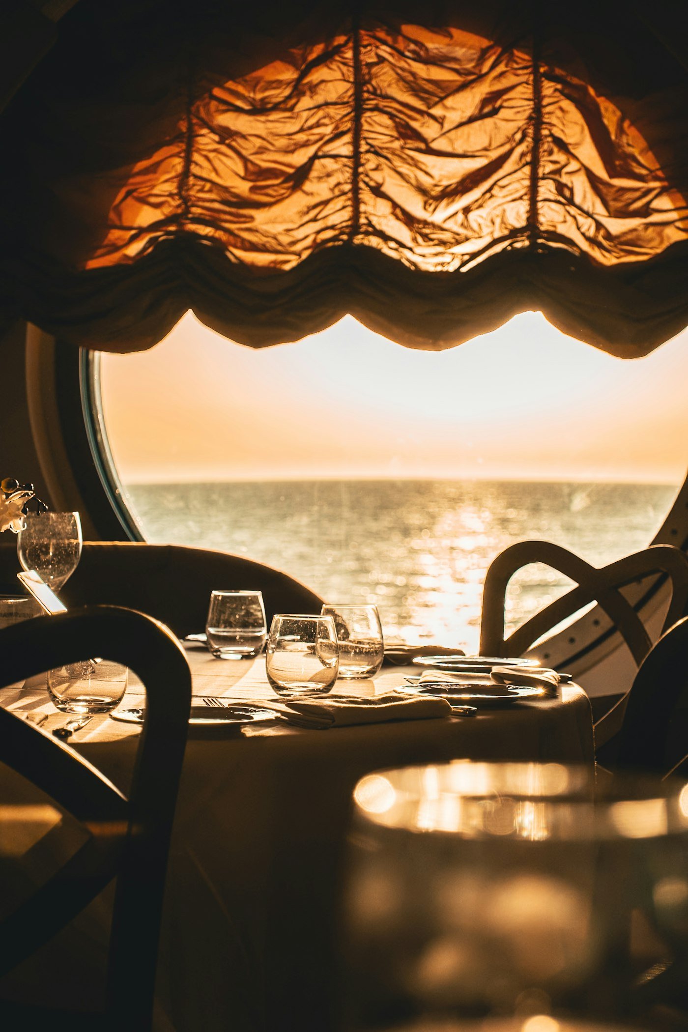 Table dressée face à la mer au coucher du soleil